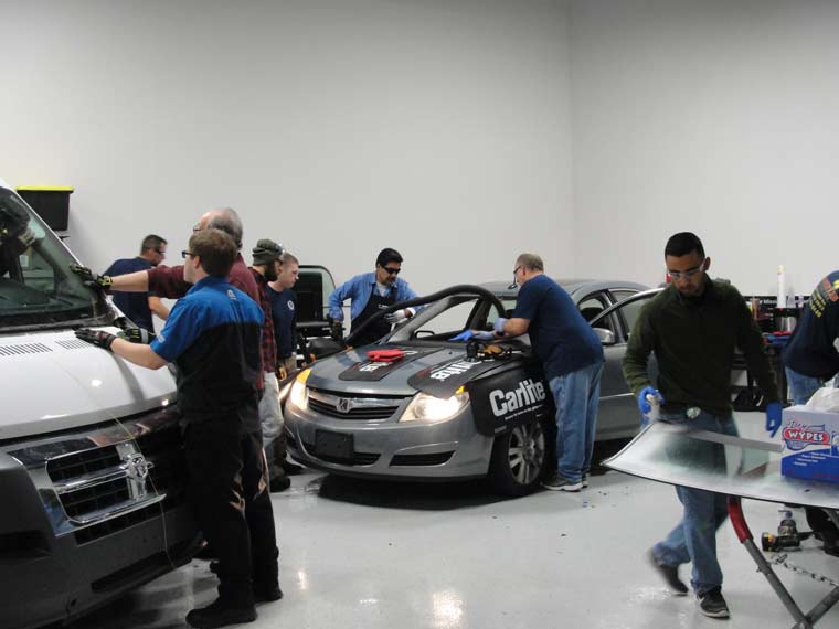 Auto Glass University students getting hands-on experience installing windshields