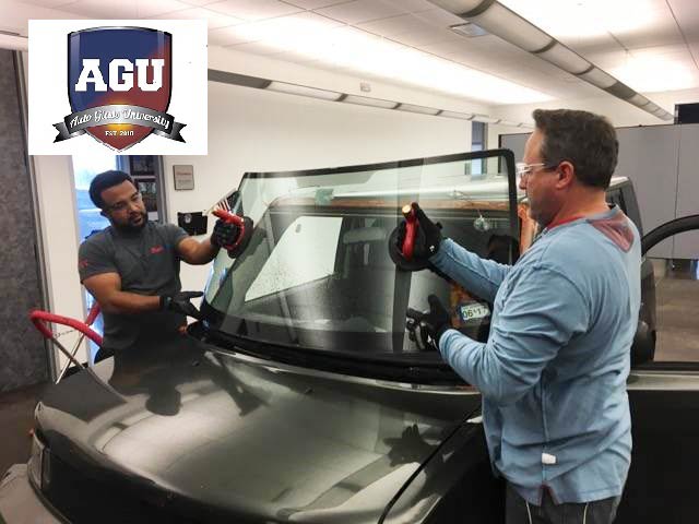 Two AGU students setting a car windshield